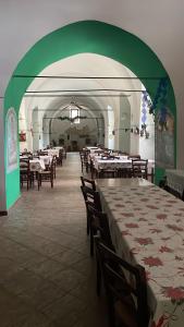 a dining room with tables and chairs and a green ceiling at Oasi Rupestre in Montescaglioso
