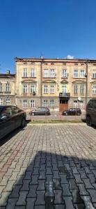 a large brick building with cars parked in front of it at Serce Przemyśla Classic in Przemyśl