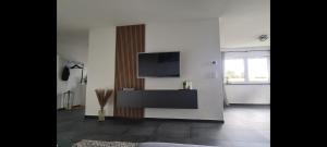 ein Wohnzimmer mit einem Flachbildfernseher an der Wand in der Unterkunft M&M AusZeit im Schwabenländle in Winterlingen + 3 Fotos