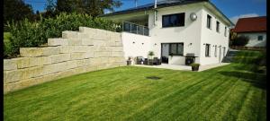 ein Haus mit einer Mauer und einem Hof in der Unterkunft M&M AusZeit im Schwabenländle in Winterlingen