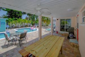 un patio avec une table en bois et une piscine dans l'établissement The Golf Cart to Beach Hideaway!, à Clearwater Beach
