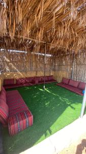 a room with red seats in a straw hut at Stars camp in Al Raka
