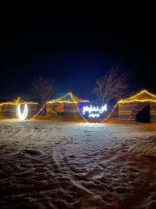 a group of tents with lights at night at Stars camp in Al Raka +5 photos