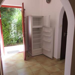 an open door to a room with an open refrigerator at Alexandra Vendégház Siófok in Siófok