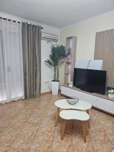 a living room with a tv and a table at Roxy's house in Vlorë