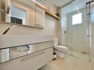 a bathroom with a toilet and a glass shower at Phoenix Tower FG - Lazer Resort a Passos do Mar BC in Balneário Camboriú +5 photos