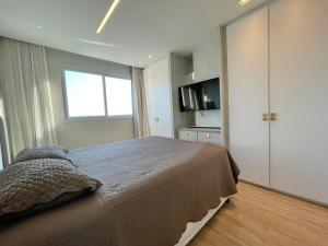 a bedroom with a large bed and a window at Phoenix Tower FG - Lazer Resort a Passos do Mar BC in Balneário Camboriú