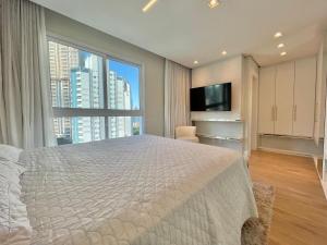 a bedroom with a large bed and a large window at Phoenix Tower FG - Lazer Resort a Passos do Mar BC in Balneário Camboriú