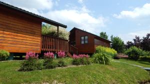 ein Haus mit einem Garten mit Blumen davor in der Unterkunft Domki nad Potokiem in Solina