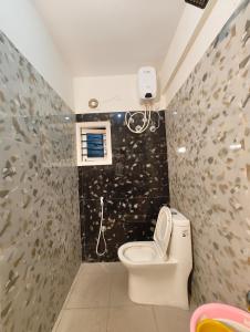 Ein Badezimmer mit Toilette und einer Wand mit Fischfliesen in der Unterkunft Namasvi 2Bedroom AC House in Narasimharaja Puram