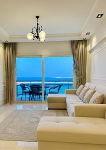 a living room with a couch and a view of the ocean at ALEX HOMES - Gleem Luxury Apartments with Direct Sea View in Alexandria