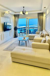 a living room with a couch and a table at ALEX HOMES - Gleem Luxury Apartments with Direct Sea View in Alexandria