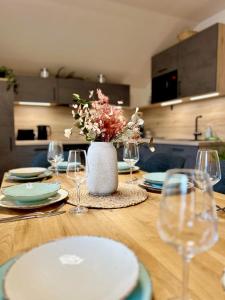 a wooden table with plates and glasses and a vase with flowers at Jagagütl in Saalfelden am Steinernen Meer