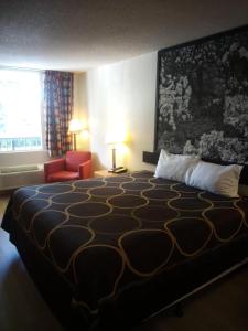 a hotel room with a large bed and a red chair at MHO Hotel Dover in Dover