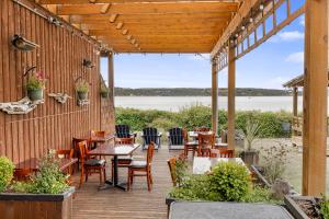 a patio with tables and chairs and a view of the water at Camano Island Inn in Camano