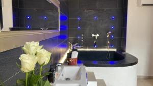 a bathroom with a sink and a tub with blue lights at Havre de paix en Provence in Jonquières