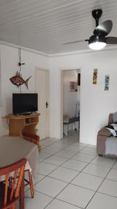 ein Wohnzimmer mit einem Bett und einem Tisch und einem Fernseher in der Unterkunft Casa da Cal in Torres