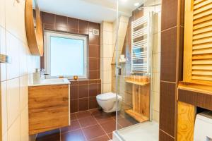 une salle de bain avec toilettes, lavabo et fenêtre dans l'établissement W parku przy teatrze, à Szczawno-Zdrój 53 autres photos