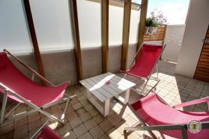 3 Stühle und ein Tisch auf dem Balkon in der Unterkunft La maison de perros in Perros-Guirec