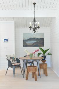 a dining room with a table and chairs and a chandelier at Scandinavian Cottage by the Sea, Close Walk to Ferry and Town in Winslow