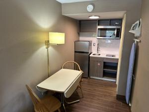 une petite cuisine avec une table et un réfrigérateur dans l'établissement Red Roof Inn & Suites Marysville, à Marysville