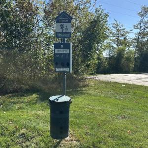 un panneau de rue avec une poubelle dans l'herbe dans l'établissement Red Roof Inn & Suites Marysville, à Marysville