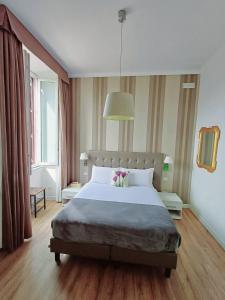 ein Schlafzimmer mit einem großen Bett und einem großen Fenster in der Unterkunft Camera x2 con splendida vista sulle Terme di Diocleziano e sul Chiostro di Michelangelo in Rom