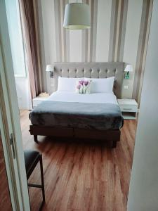 ein Schlafzimmer mit einem großen Bett mit großem Kopfteil in der Unterkunft Camera x2 con splendida vista sulle Terme di Diocleziano e sul Chiostro di Michelangelo in Rom