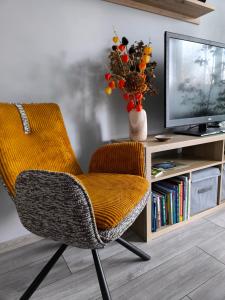 una silla en la sala de estar con TV en Ludza stay Apartment, en Ludza 36 fotos más