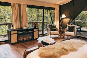 a bedroom with a fireplace and a bed in a room at Luxury Glamping Tent - The Perch - Near Tryon Equestrain Center in Mill Spring