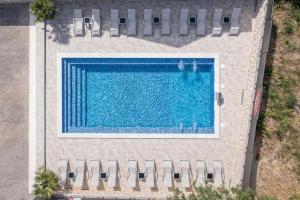 an overhead view of a swimming pool with chairs at BUDGET RESORT Vagabundo in Novalja