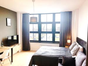 a bedroom with a bed and a large window at Apartimento Hydral Viene in Wrocław