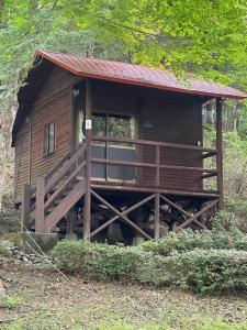 Cette petite cabane en bois dispose d'une terrasse couverte dans les bois. dans l'établissement Sky Lodge Gingamura - Vacation STAY 84488v, à Shironita