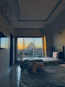 a bedroom with two beds and a view of a mountain at Continental Pyramids Terrace Hotel in Cairo +43 photos