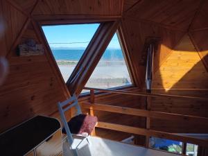 an attic room with a view of the ocean at La Morada del Lago in Tolhuin
