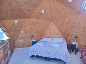 a bedroom with a bed in a wooden ceiling at La Morada del Lago in Tolhuin
