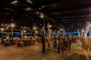 Un restaurante con mesas y sillas de madera y luces. en BUDGET RESORT Vagabundo, en Novalja