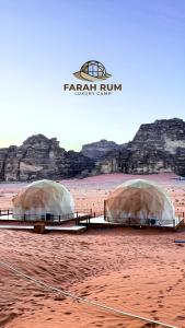 two domes in the desert with rocks in the background at FARAH RUM lUXURY CAMP in Wadi Rum