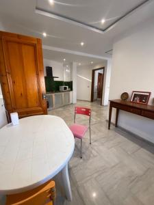 a room with a white table and a red chair at Charmant appartement à Carthage in Douar ech Chott +4 photos