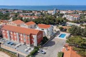 Una vista aérea de un edificio con estacionamiento. en BUDGET RESORT Vagabundo, en Novalja
