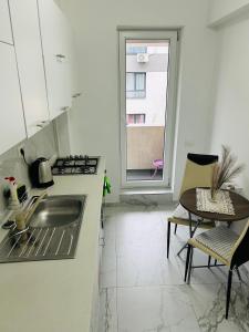 a kitchen with a sink and a table and a window at Bella Home2 in Roşu