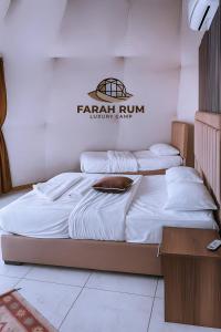 two beds in a room with a sign on the wall at FARAH RUM LUXURY CAMP & Bubbles Hotel in Wadi Rum