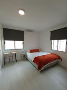 a bedroom with a bed and a table and windows at Estudios Diego in Puerto de Sagunto