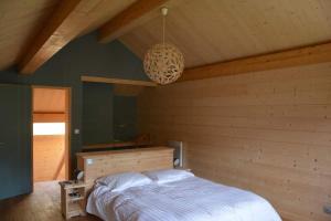 a bedroom with a bed and a chandelier at Cozy Chalet With Scenic View In Monêtier Les Bains in Le Monêtier-les-Bains