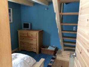 a bedroom with a bed and a wooden dresser and a staircase at Cozy Chalet With Scenic View In Monêtier Les Bains in Le Monêtier-les-Bains