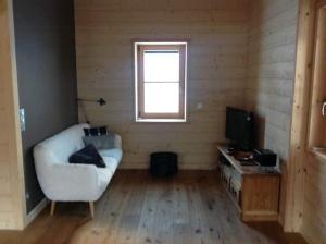 a living room with a couch and a television at Cozy Chalet With Scenic View In Monêtier Les Bains in Le Monêtier-les-Bains