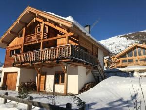 a wooden house with a balcony in the snow at Cozy Chalet With Scenic View In Monêtier Les Bains in Le Monêtier-les-Bains +12 photos