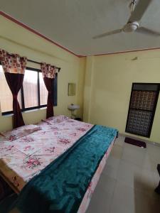 a bedroom with a bed and two windows at Shri Samarth Homestay in Diveagar