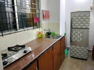 a kitchen with a stove and a sink at Alice's Cozy Abode in Udupi +34 photos