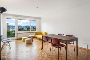 a dining room with a table and chairs and a window at EXQUIS Design 3-Room Apartment KNOLL I Zurich Lake View I Balcony I Family-Friendly in Männedorf +8 photos